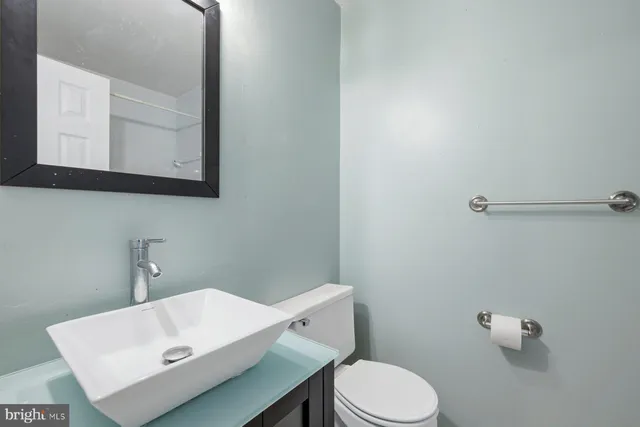 a bathroom with a toilet sink and mirror