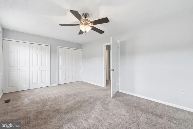 a view of an empty room and chandelier fan