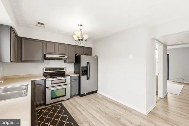 a kitchen with cabinets a sink and stainless steel appliances