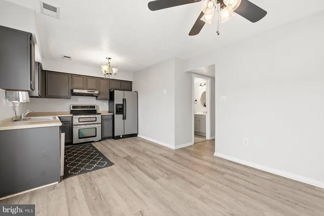 a kitchen with stainless steel appliances a refrigerator and a stove top oven