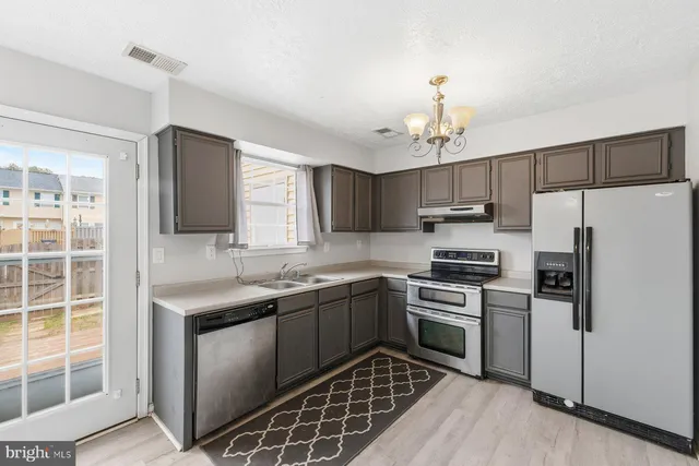 a kitchen with a sink stainless steel appliances and cabinets