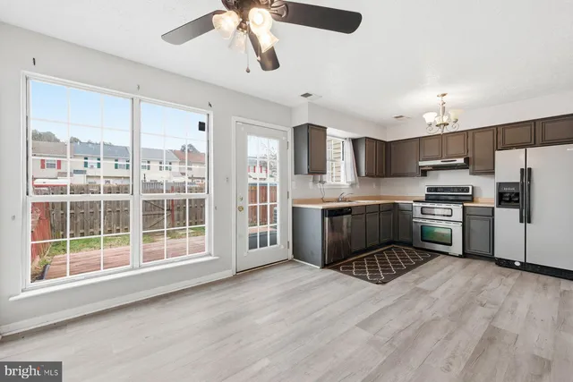 a kitchen with a refrigerator a sink and a stove top oven