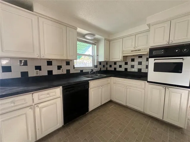 a kitchen with white cabinets and white appliances