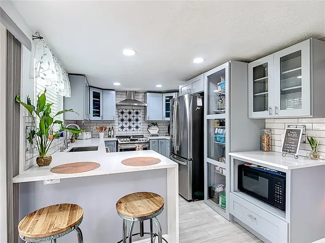 a kitchen with stainless steel appliances a sink and a refrigerator