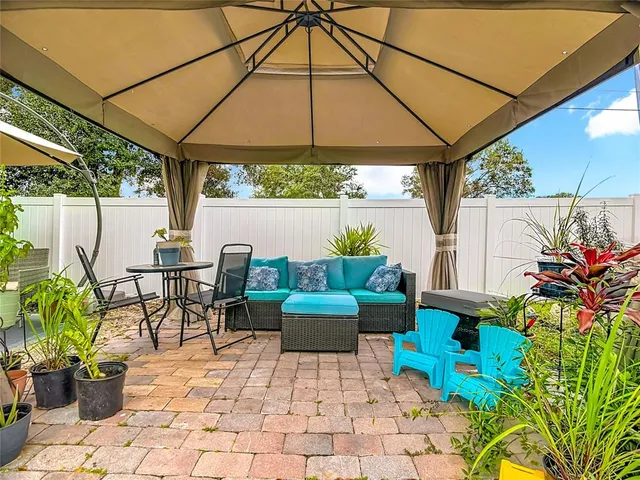 a patio with a table and chairs under an umbrella