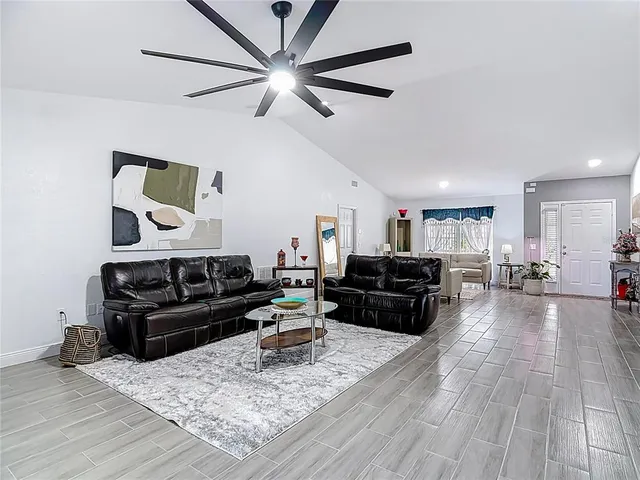 a living room with furniture and a wooden floor