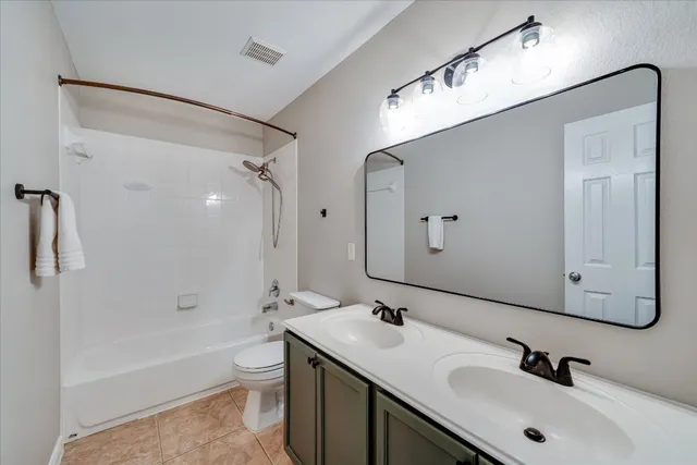 a bathroom with a bathtub shower sink mirror and toilet