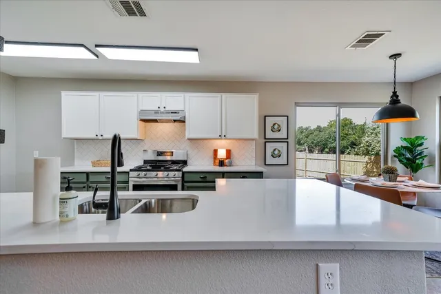 a kitchen with stainless steel appliances granite countertop a sink stove and refrigerator