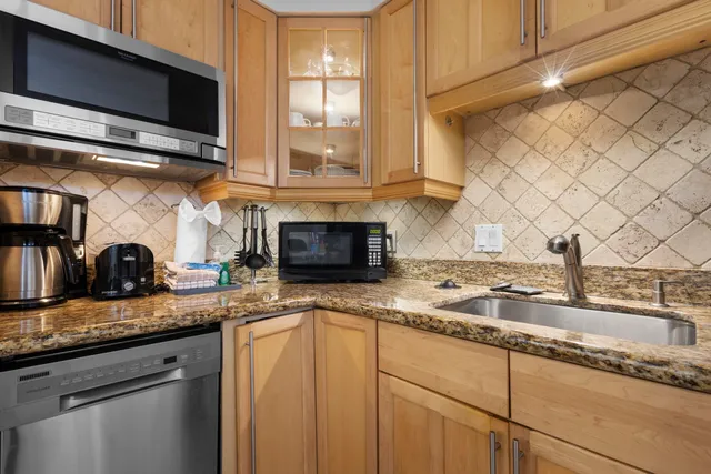 a kitchen with granite countertop a sink a stove and cabinets