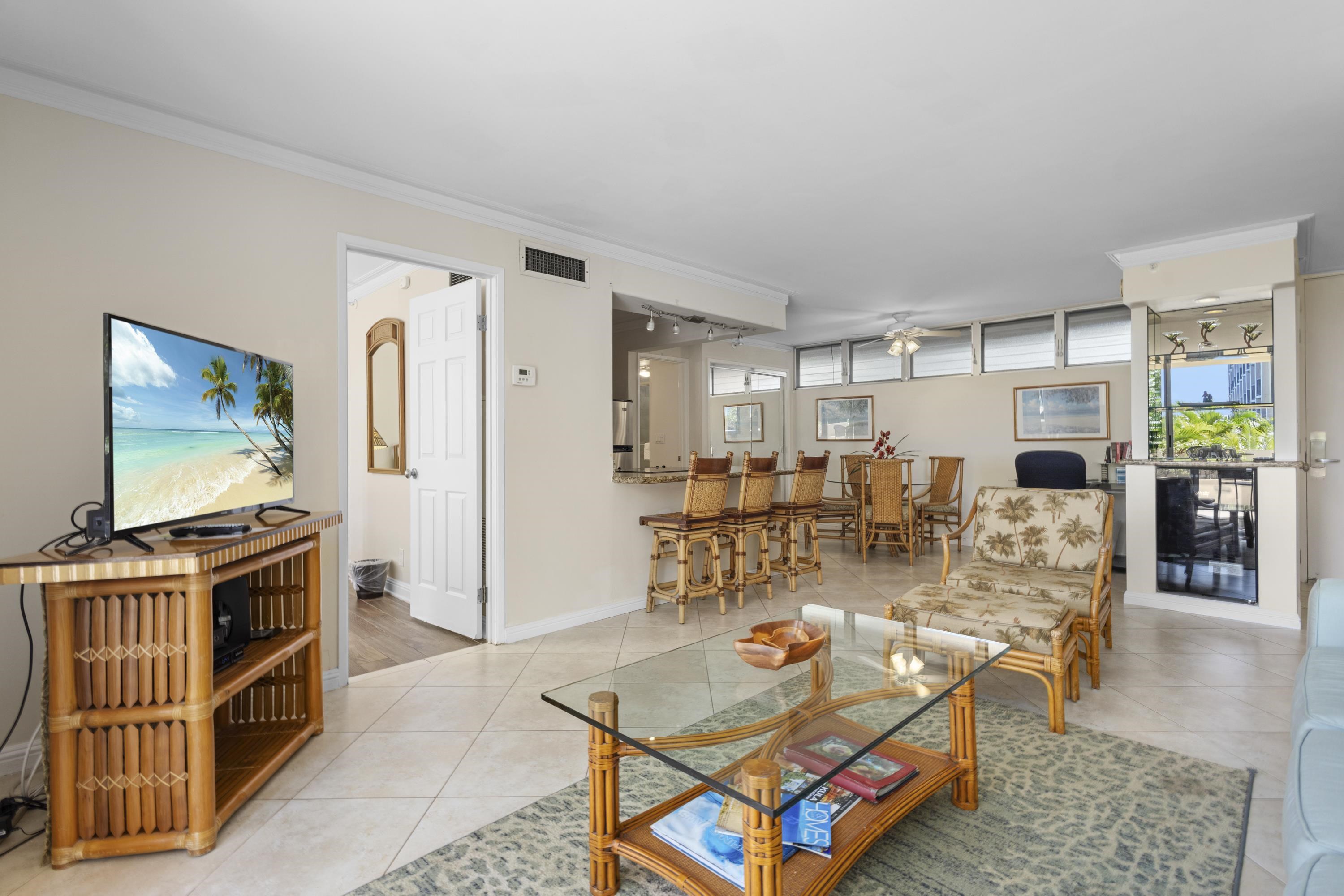 4365 Lower Honoapiilani Road, Unit 115 Lahaina, HI 96761 - Photo 13 of 44 a living room with furniture a flat screen tv and wooden floor