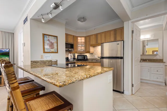 a kitchen with kitchen island granite countertop a sink appliances counter top space and living room view