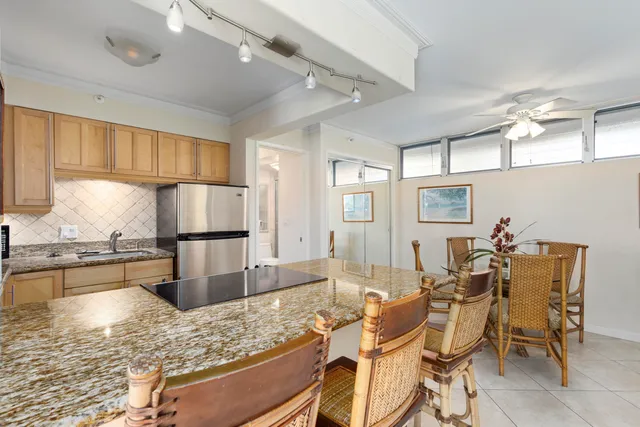 a kitchen with stainless steel appliances kitchen island granite countertop a refrigerator and a stove top oven