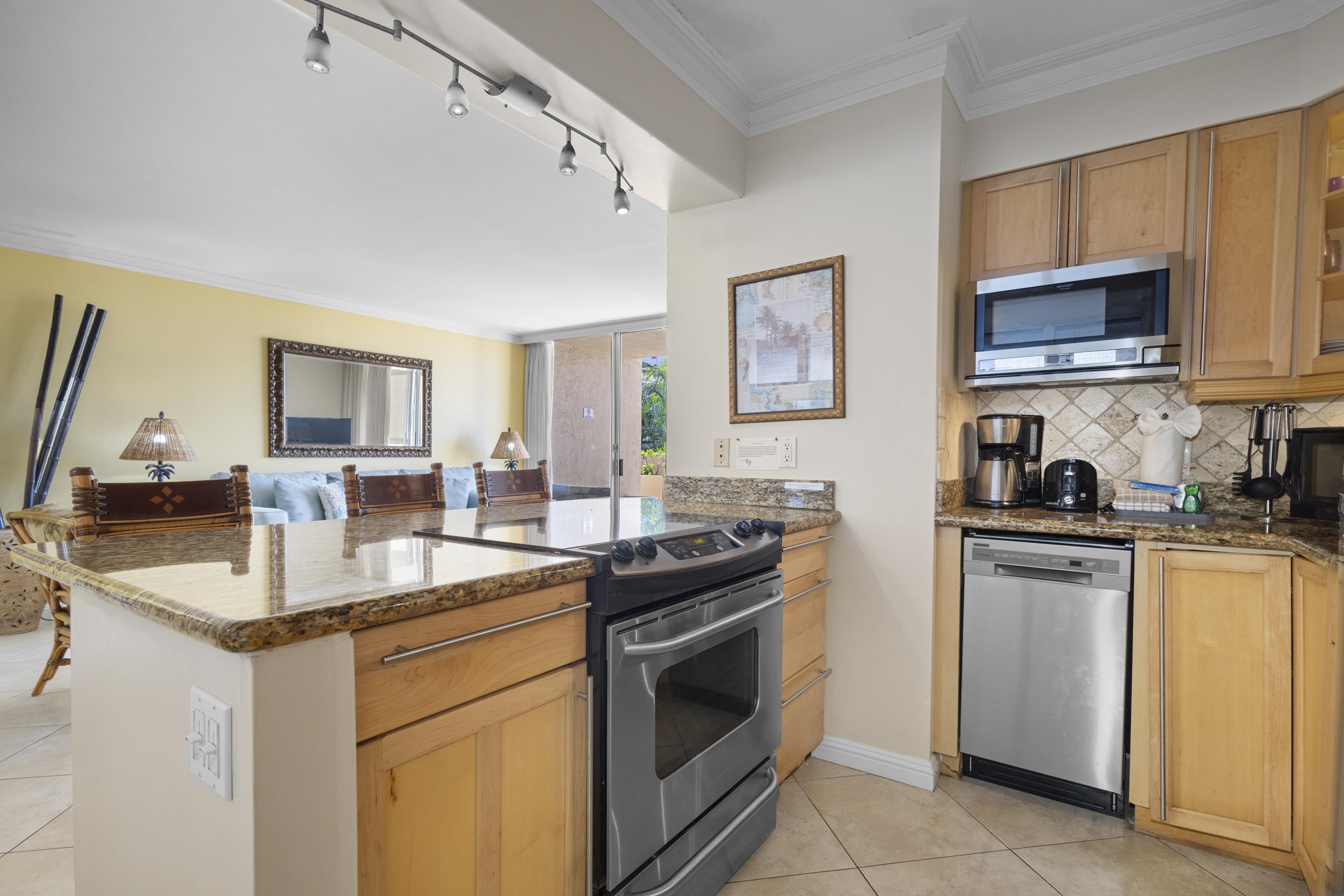4365 Lower Honoapiilani Road, Unit 115 Lahaina, HI 96761 - Photo 9 of 44 a kitchen with stainless steel appliances granite countertop a sink stove oven and microwave