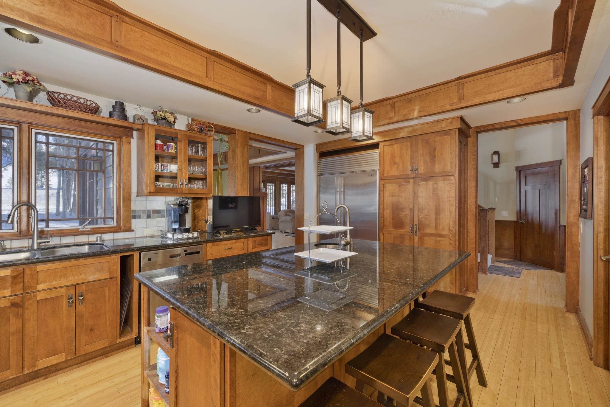 56 Wagon Road Mammoth Lakes, CA 93546 - Photo 12 of 56 Kitchen featuring brown cabinets, hanging light fixtures, a kitchen island with sink, a kitchen bar, and recessed lighting