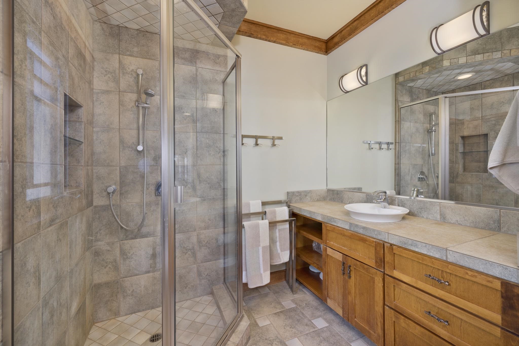 56 Wagon Road Mammoth Lakes, CA 93546 - Photo 20 of 56 Full bathroom featuring vanity, a shower stall, crown molding, and light stone finish flooring