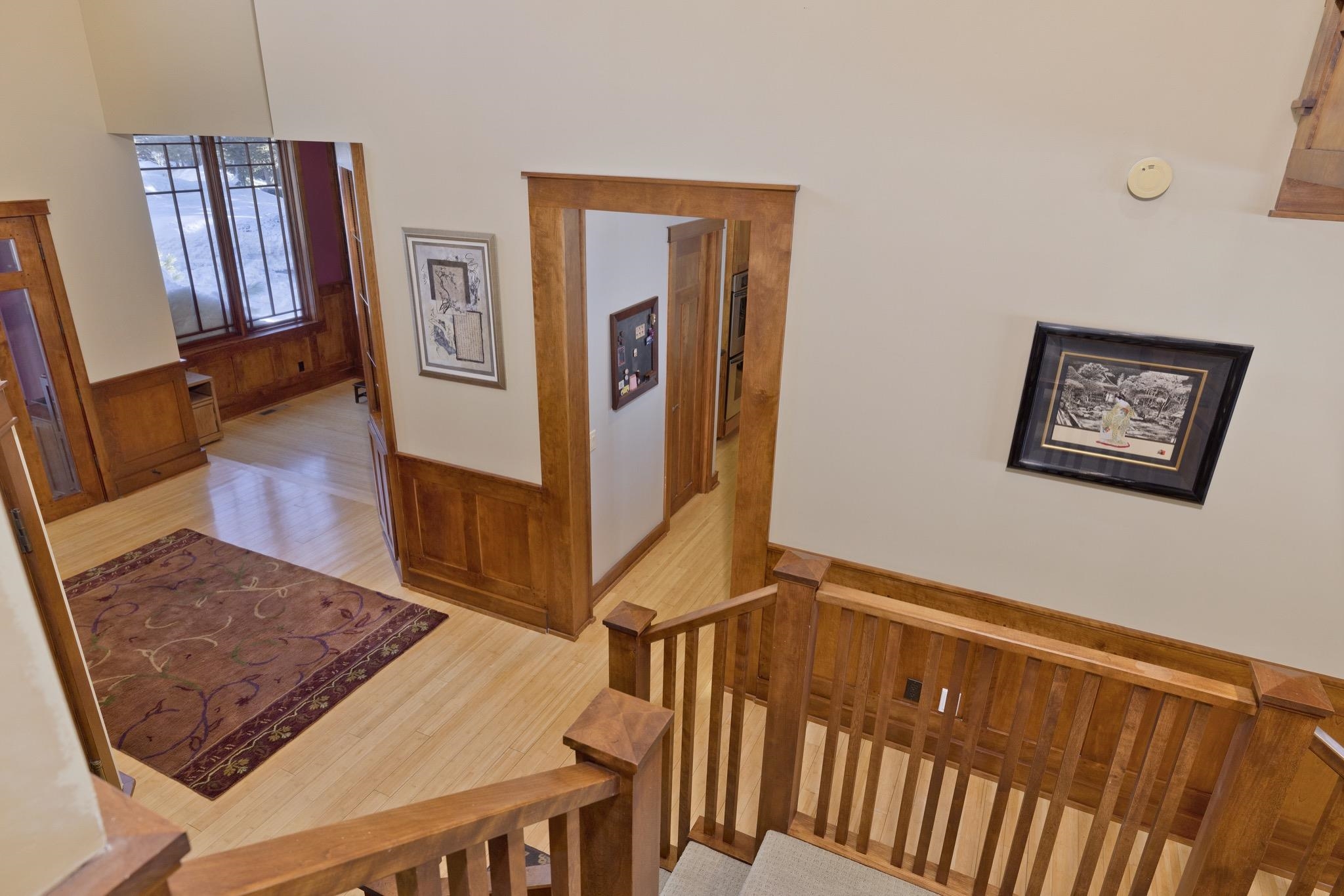 56 Wagon Road Mammoth Lakes, CA 93546 - Photo 8 of 56 Hallway featuring wood walls, wainscoting, light wood-style floors, and an upstairs landing