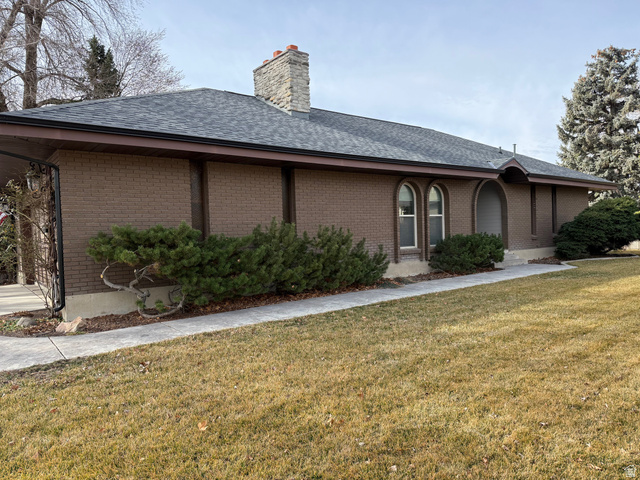 362 East 9150th Street South Sandy, UT 84070 - Photo 15 of 41 View of front of property with a front lawn, roof with shingles, brick siding, and a chimney, tons of parking.