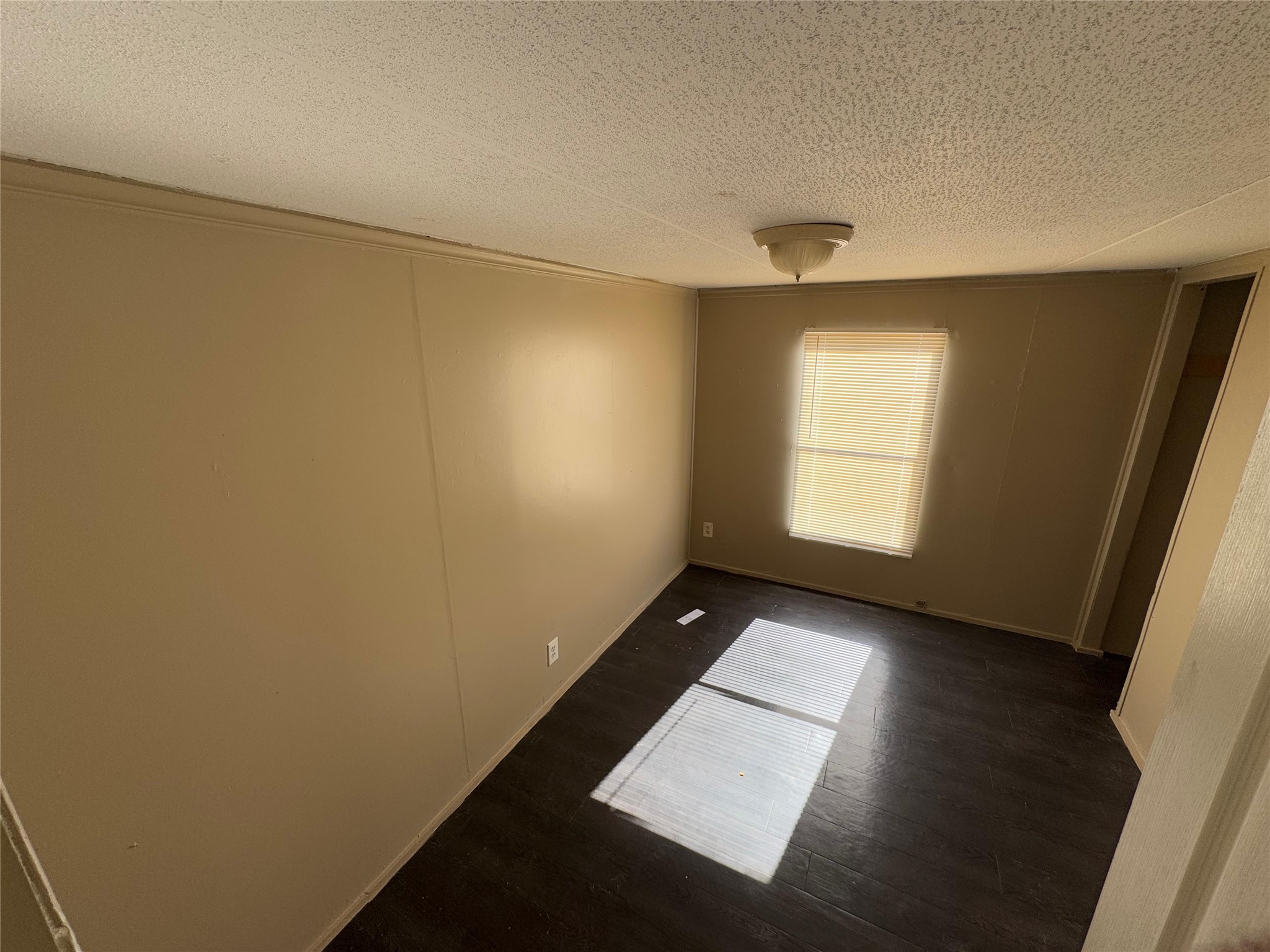 8315 Burleson Manor Road, Unit B Manor, TX 78653 - Photo 10 of 15 Spare room featuring dark wood finished floors and a textured ceiling