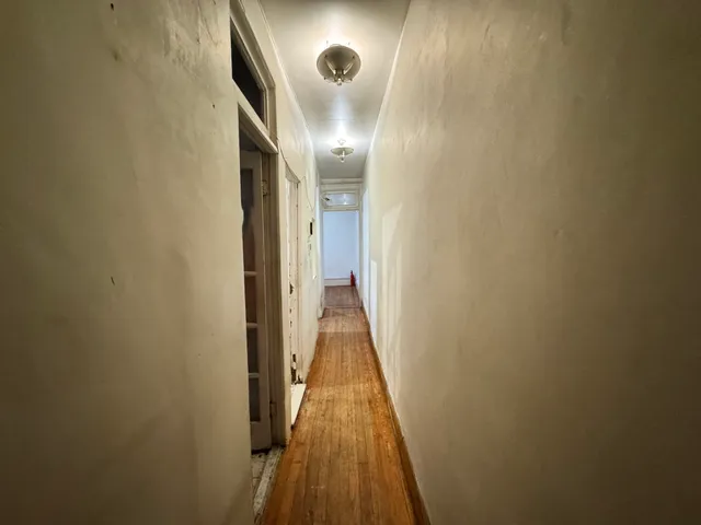 a view of a hallway with wooden floor