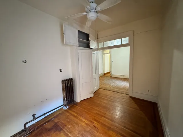 a view of a livingroom with wooden floor and a ceiling fan