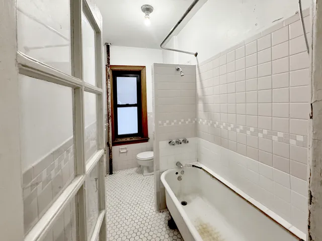 a bathroom with a tub a sink and a large mirror