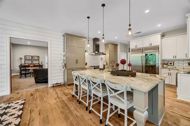a view of a dining room and livingroom with furniture wooden floor a chandelier