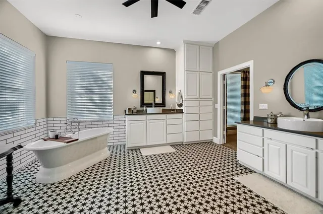 a spacious bathroom with a double vanity sink a mirror and shower