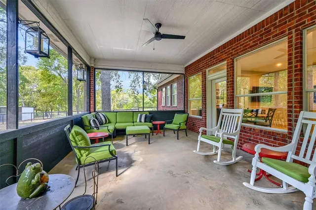 a living room with furniture a flat screen tv and a floor to ceiling window