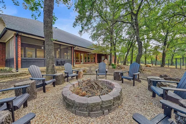 a backyard of a house with fire pit and outdoor seating