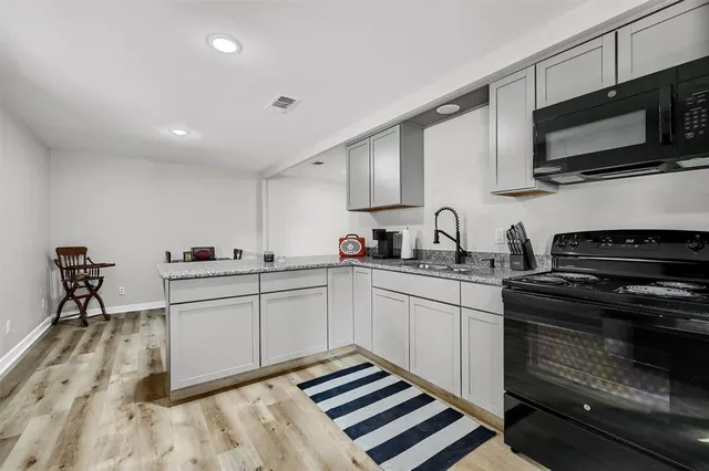 a kitchen with stainless steel appliances granite countertop a sink and a stove