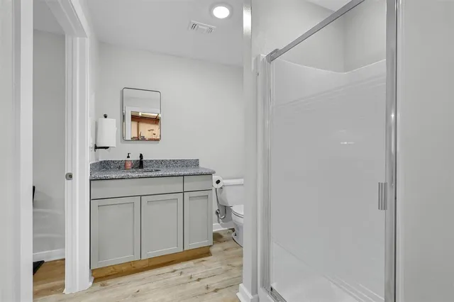 a bathroom with a granite countertop sink toilet and shower