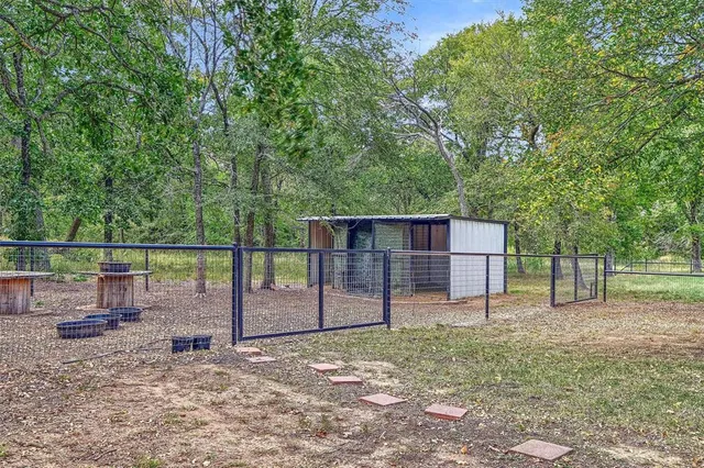a view of a backyard with wooden fence and large trees