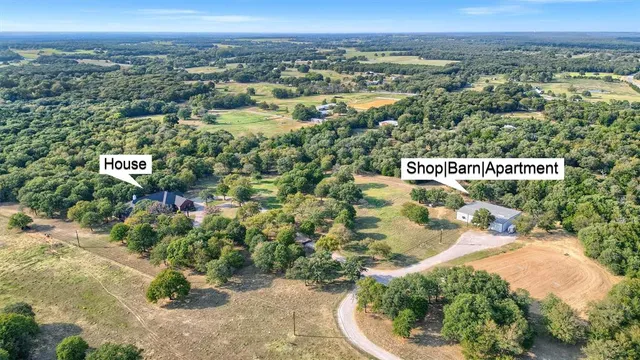 an aerial view of residential houses with outdoor space and trees