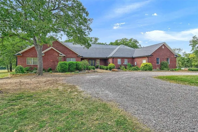 a view of large house with a big yard and large trees