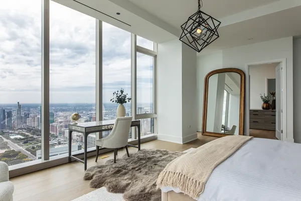 a bedroom with a bed and large window with balcony view