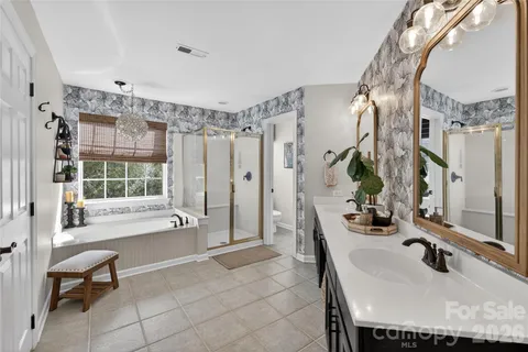a bathroom with a sink tub vanity and shower