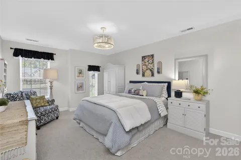 a spacious bedroom with a bed a couch and a window