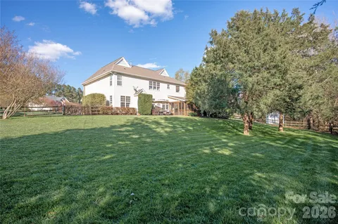 a view of a house with a big yard and large trees