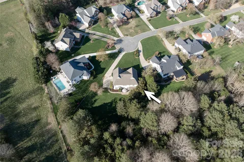 an aerial view of residential houses with outdoor space and parking