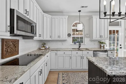 a kitchen with stainless steel appliances granite countertop a stove microwave and cabinets