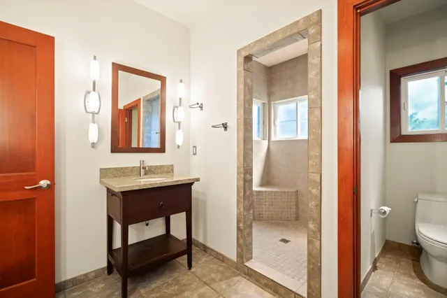 a bathroom with a granite countertop double vanity sink a mirror and a