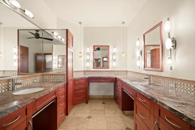 a bathroom with a granite countertop sink and a shower