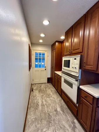 a view of an empty room and kitchen