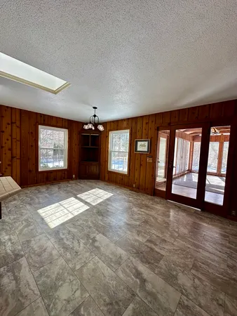 a view of an empty room with a fireplace and a window