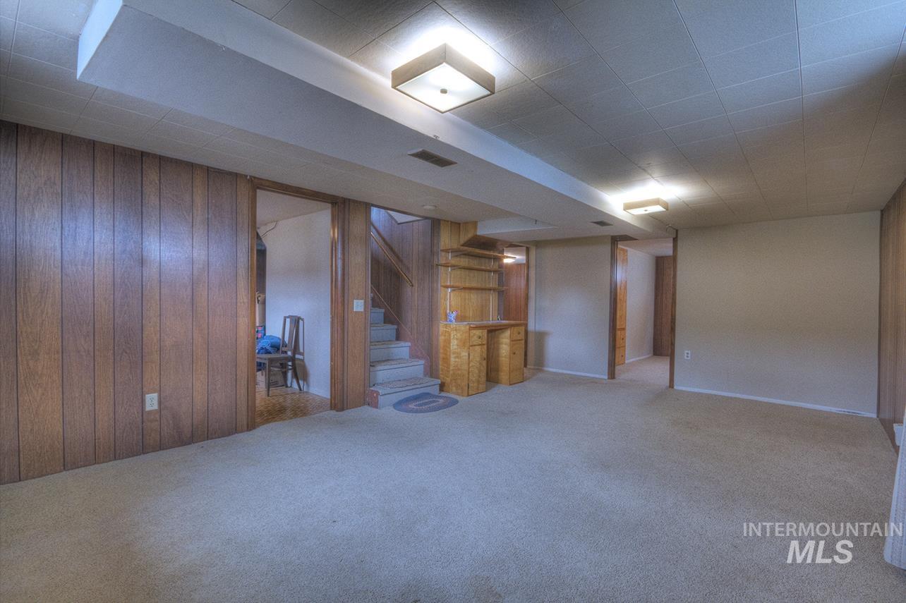 351 West Main Street South Vale, OR 97918 - Photo 9 of 33 Spacious lower-level room featuring wood paneling, a built-in wood-finish bar with shelving, carpeted flooring, and recessed lighting
