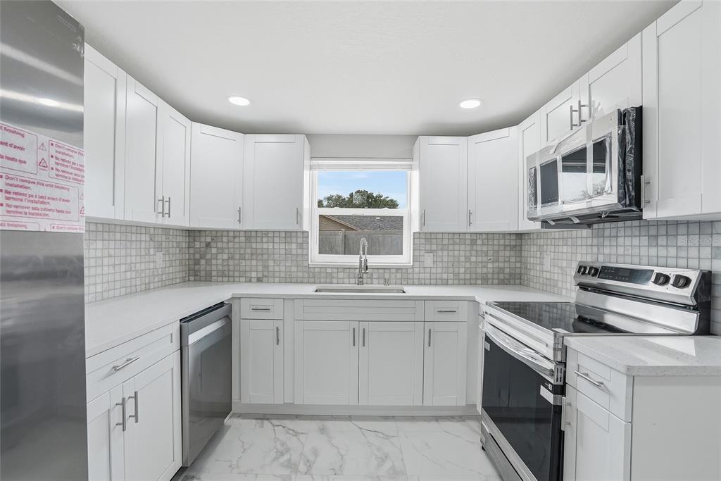 6302 Diamond Drive New Port Richey, FL 34653 - Photo 12 of 43 a kitchen with a sink stove and cabinets