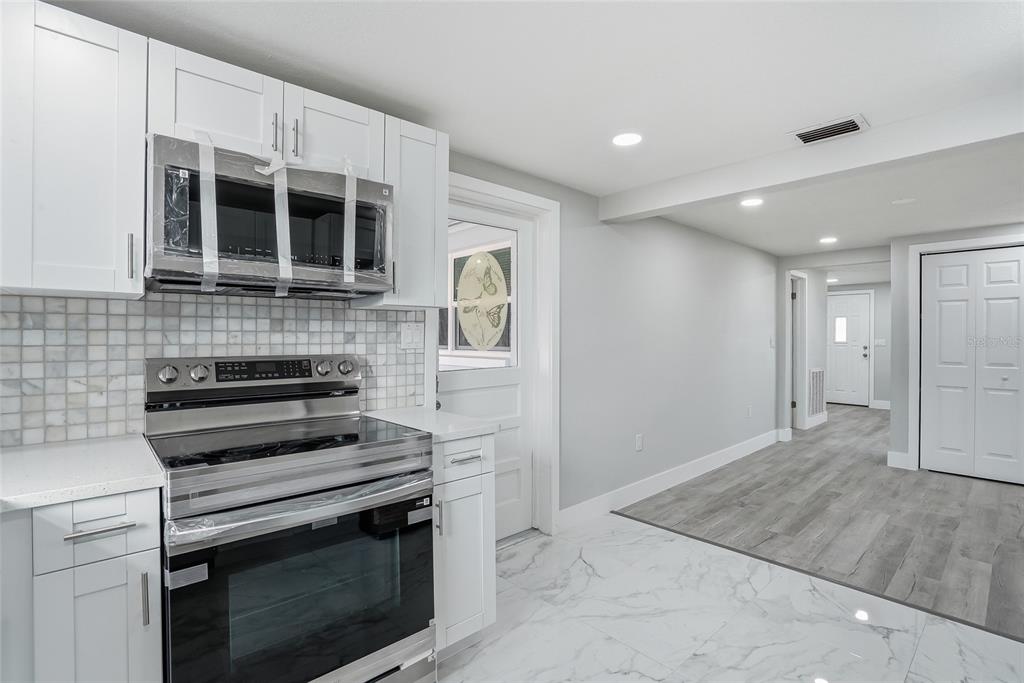 6302 Diamond Drive New Port Richey, FL 34653 - Photo 14 of 43 a kitchen with a stove and a microwave