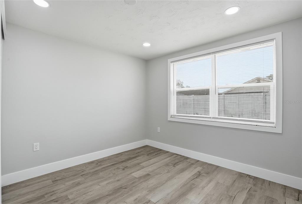 6302 Diamond Drive New Port Richey, FL 34653 - Photo 28 of 43 a view of an empty room with wooden floor and a window