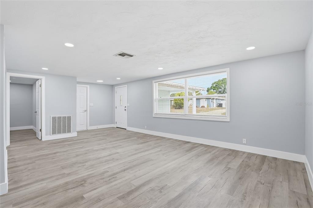 6302 Diamond Drive New Port Richey, FL 34653 - Photo 6 of 43 a view of an empty room with wooden floor and a window