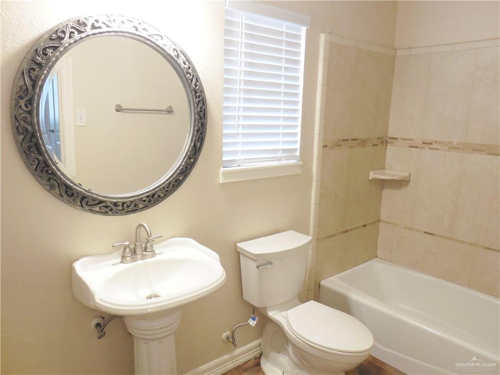 5212-5213 North Taylor Road Mission, TX 78573 - Photo 14 of 20 a bathroom with a sink a toilet and a mirror